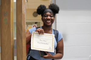  student holding award certificate
