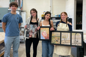 Students holding artwork